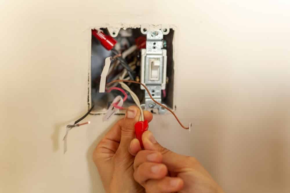 electrician is replacing a wall switch