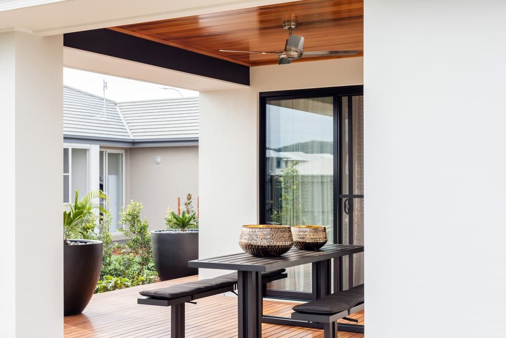 A contemporary style Patio with a stylish black snack counter and benches and two black high flower pots