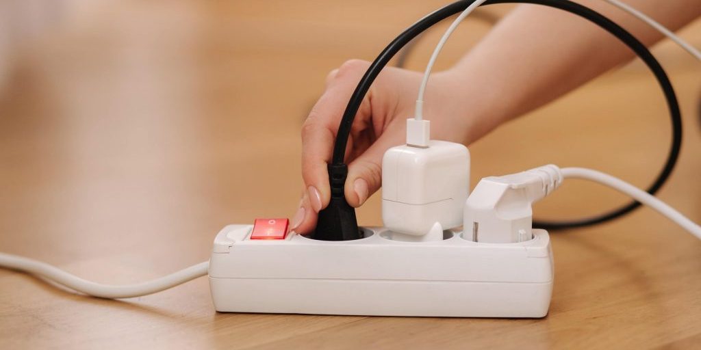 Woman pluging the wire into white extension cord